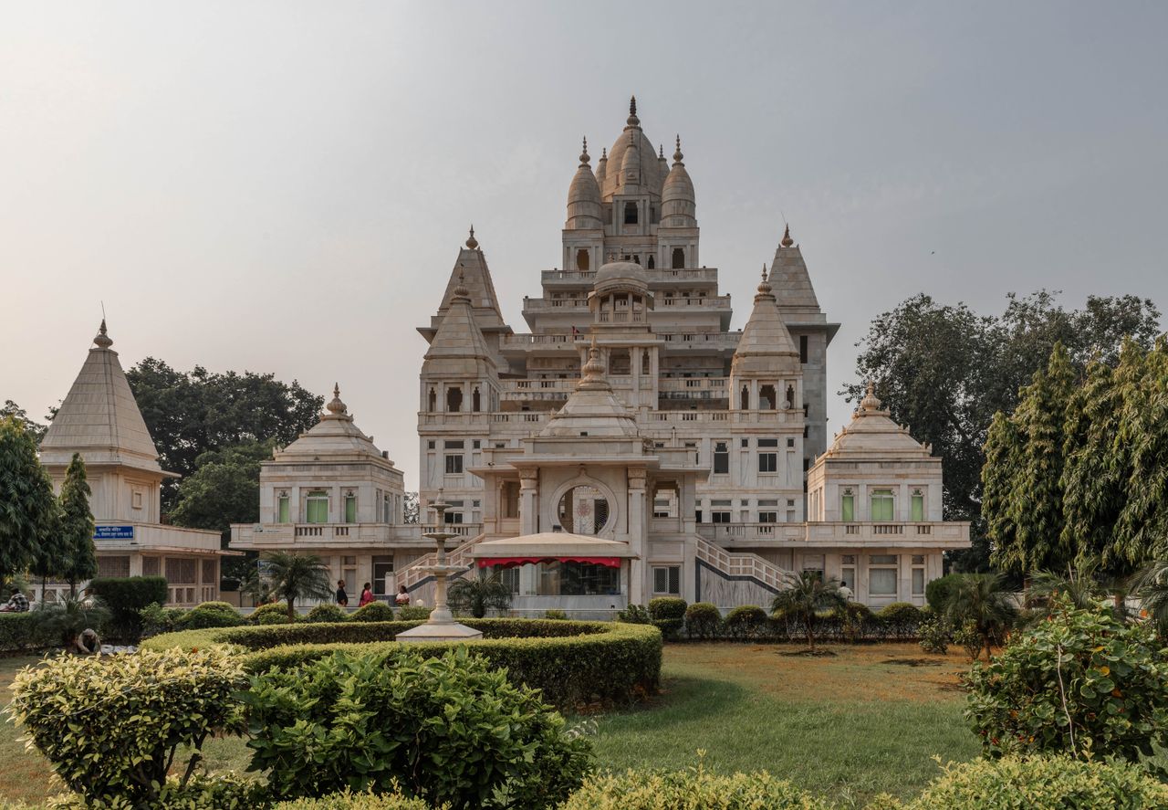 Stunning view of a temple in Vrindavan, showcasing intricate architecture and lush gardens.